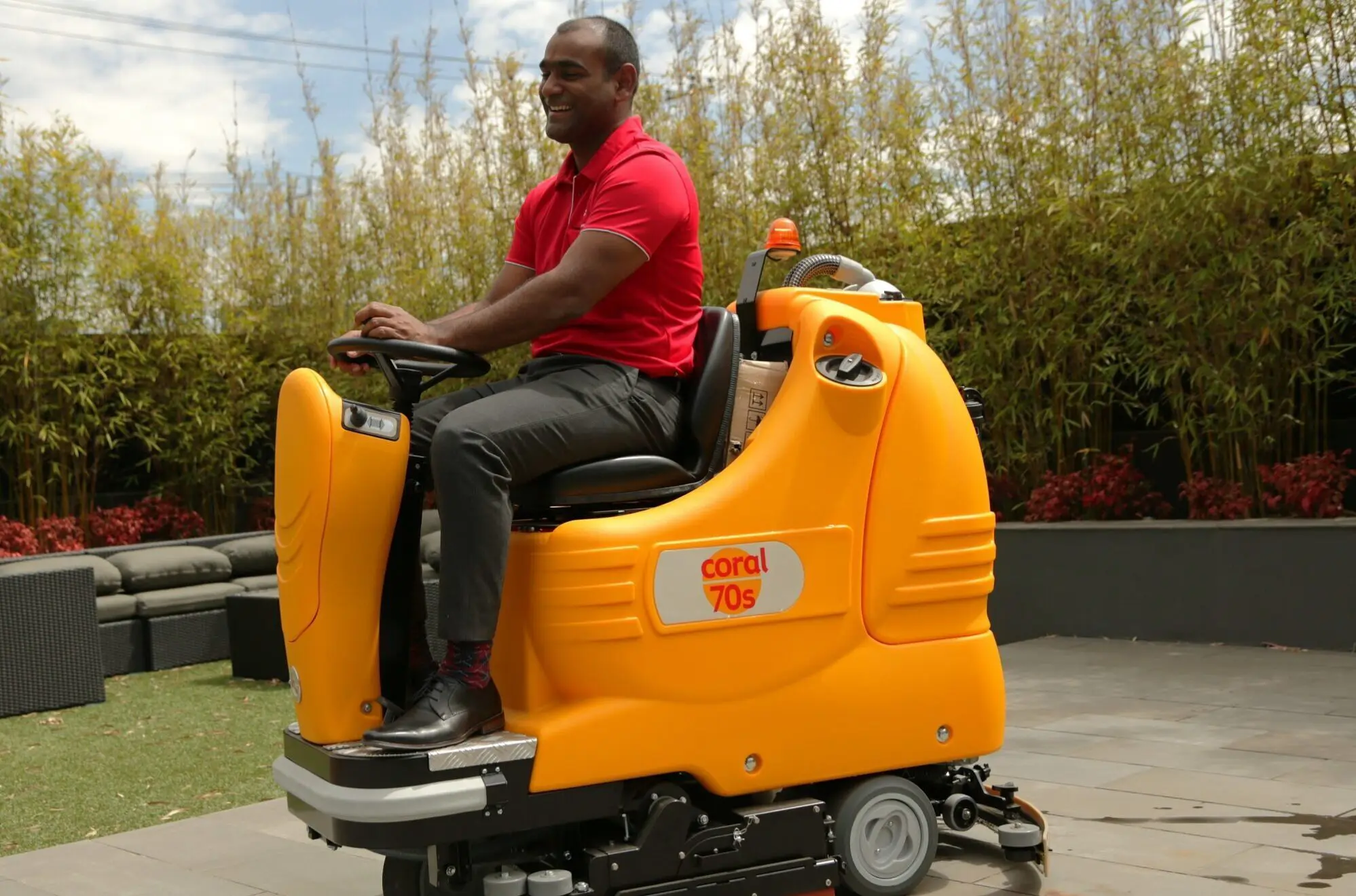 Cleaner riding a scrubbing floor cleaning machine to clean a large industrial floor