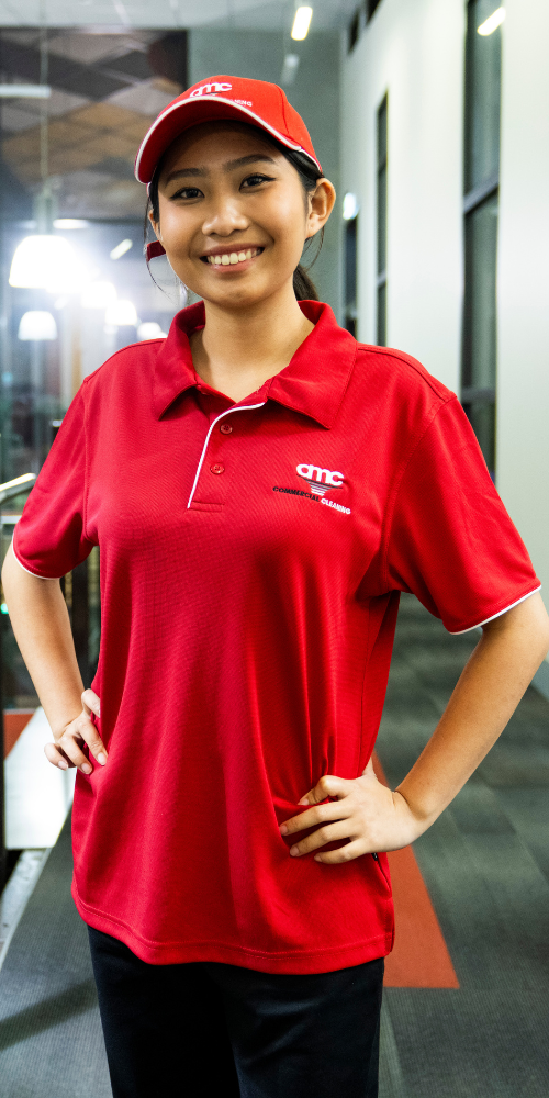 AMC cleaner in uniform smiling while servicing a corporate office facility in south east melbourne